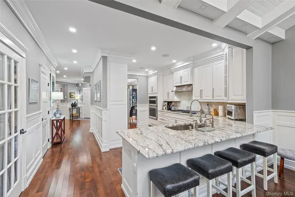 a kitchen with granite countertop kitchen island wooden floor center island and stainless steel appliances