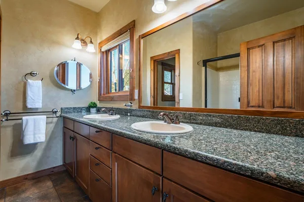 a bathroom with a granite countertop sink and a mirror