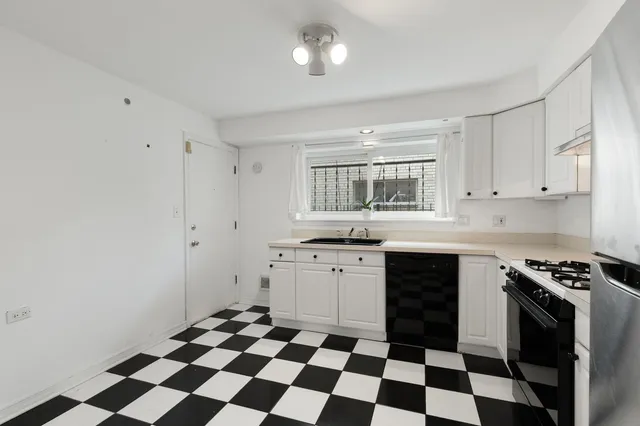a kitchen with a checkered floor and white cabinets