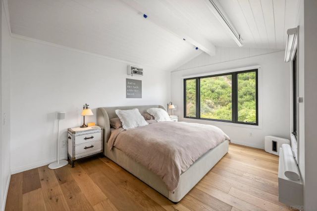 a bedroom with a bed and a large window