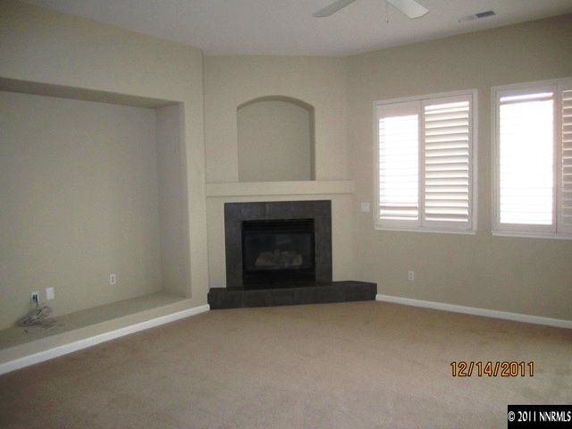 2495 Baton Drive Reno, NV 89521 - Photo 5 of 13 a view of an empty room with a fireplace and a window