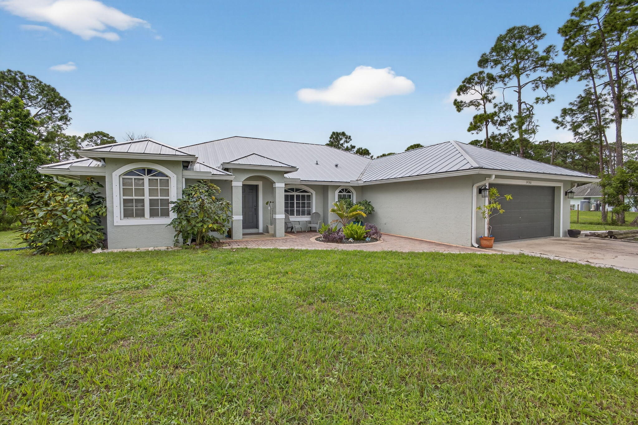 a front view of a house with a garden and yard