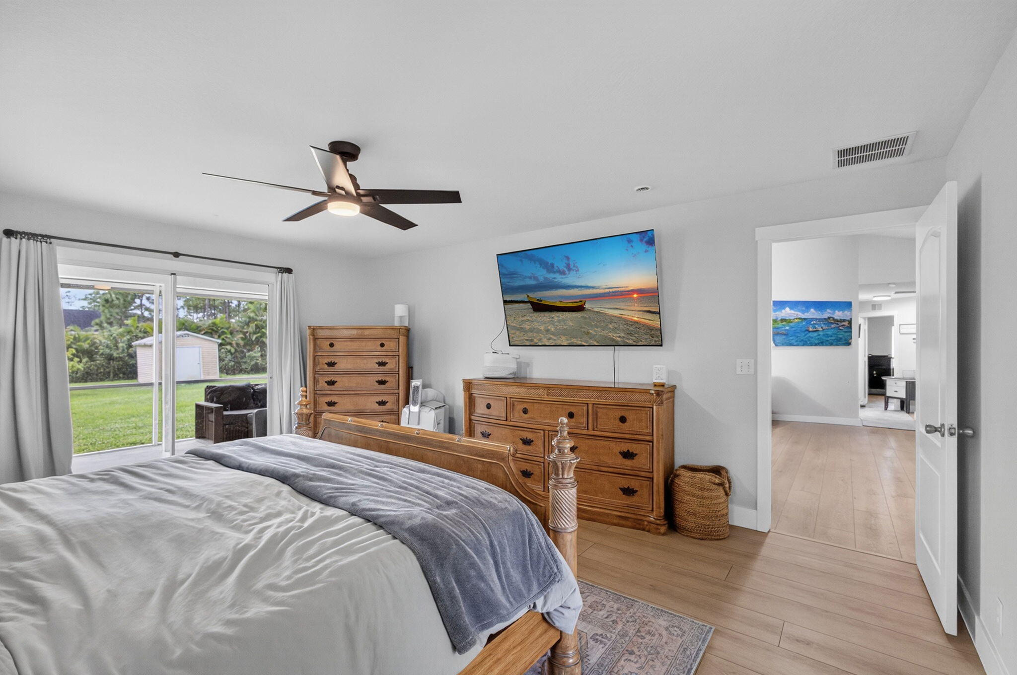 14366 76th Road North The Acreage, FL 33470 - Photo 43 of 76 a bedroom with a bed a dresser and a flat screen tv