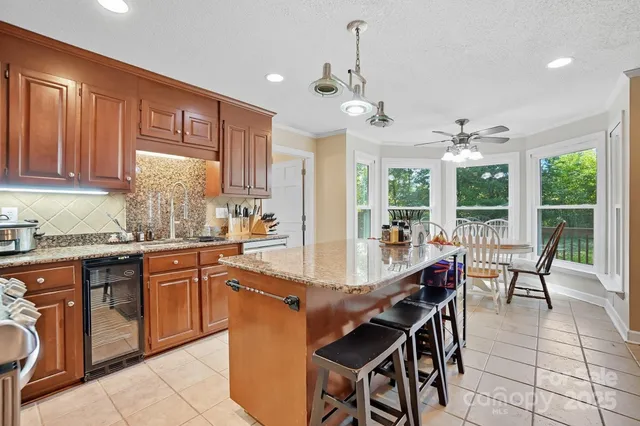 a kitchen with granite countertop a table chairs sink and cabinets