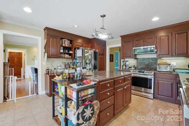 a kitchen with stainless steel appliances granite countertop a stove and cabinets