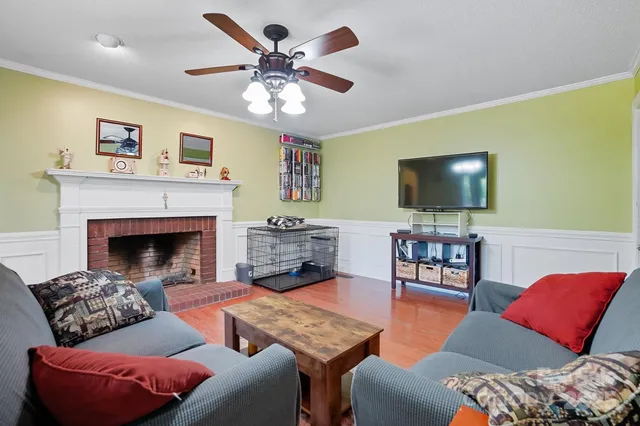 a living room with furniture and a flat screen tv with wooden floor