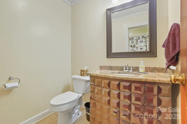 a bathroom with a granite countertop toilet and a sink