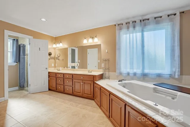 a large bathroom with a tub a sink shower and mirror