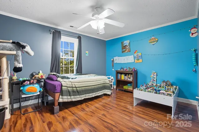 a bedroom with furniture and a wooden floor