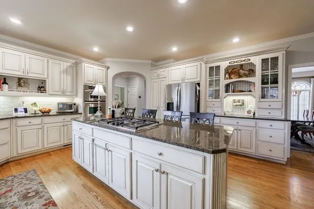 a view of a dining room and livingroom with furniture wooden floor a chandelier