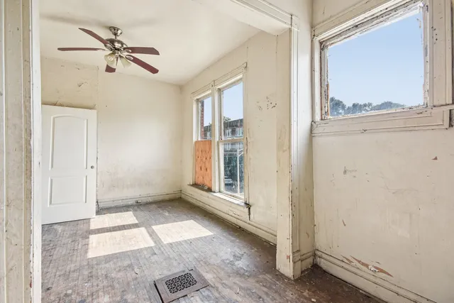 a view of an empty room with wooden floor