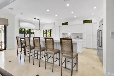 a view of kitchen with stainless steel appliances cabinets table and chairs