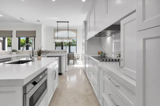 a large white kitchen with a large window