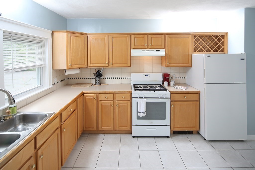 137 Mendon Road Attleboro, MA 02703 - Photo 5 of 24 a kitchen with a stove a sink and a refrigerator