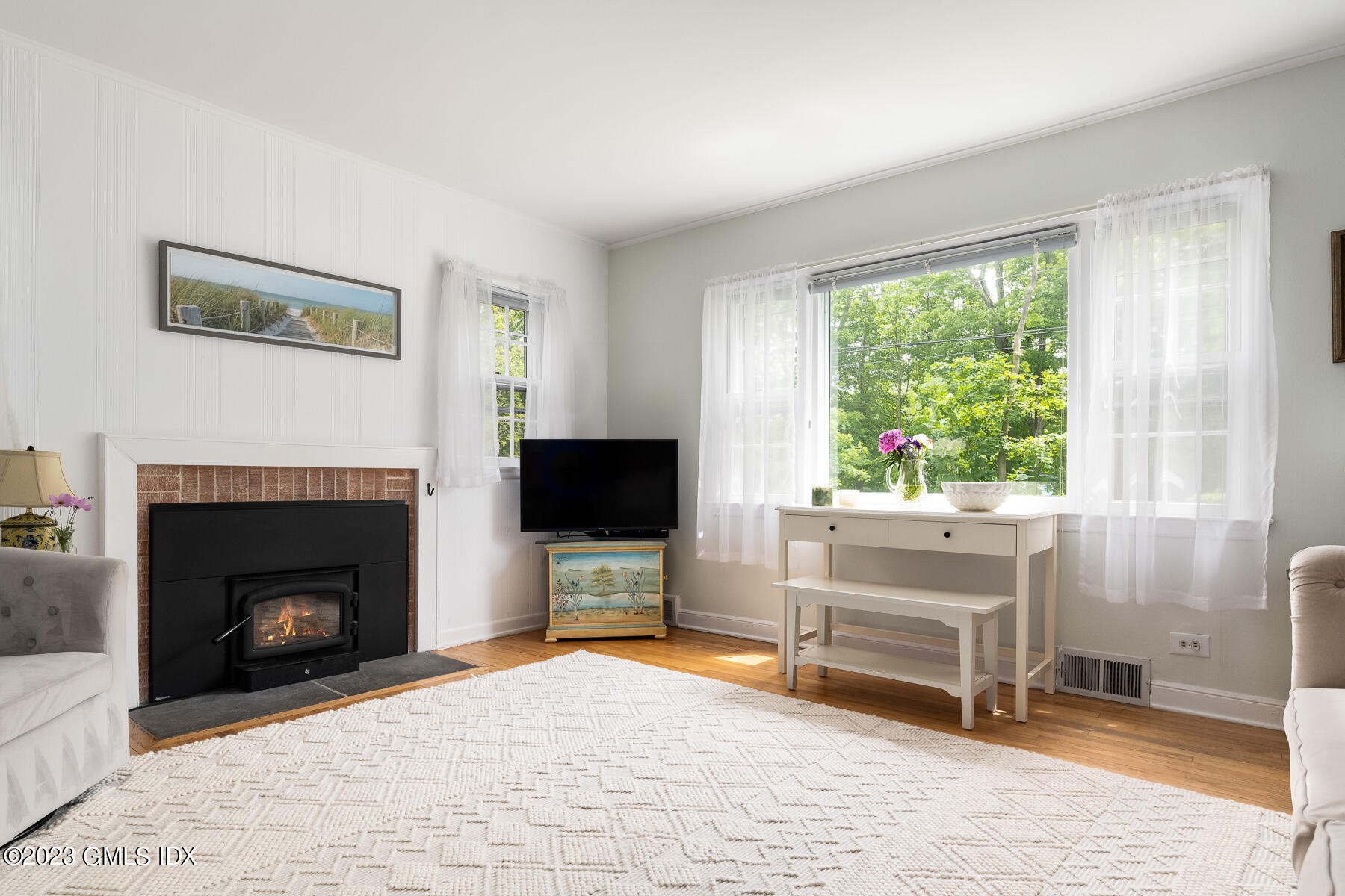 7 Wilmot Lane Riverside, CT 06878 - Photo 7 of 22 a living room with furniture a fireplace and a flat screen tv