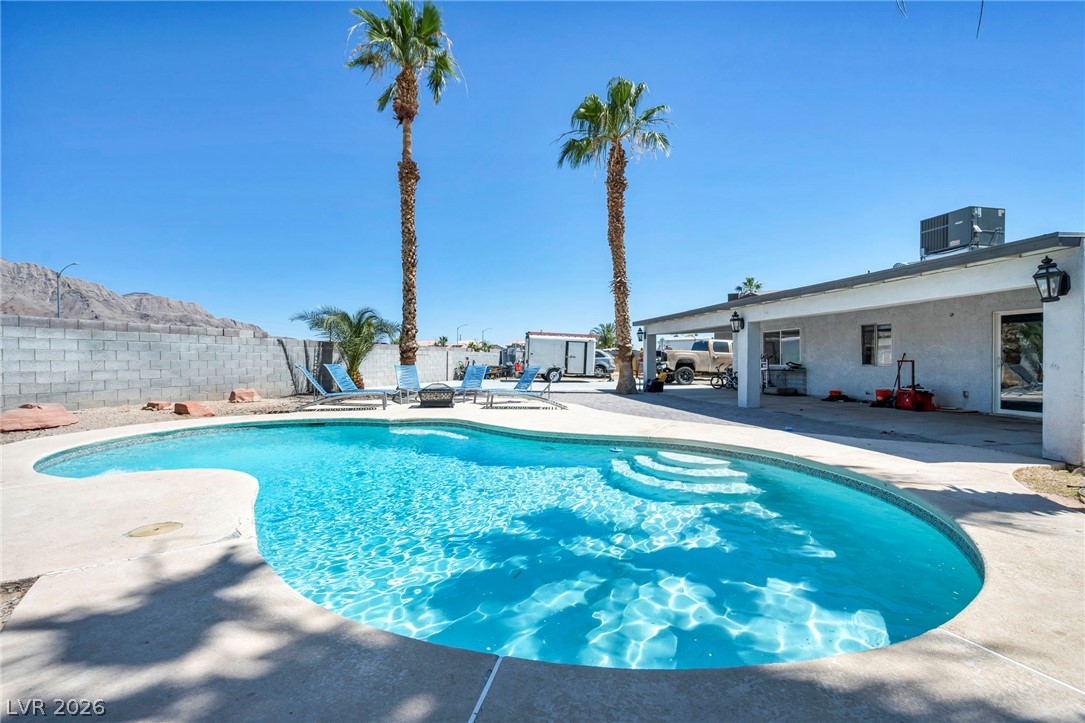 5882 Rio Tinto Way Las Vegas, NV 89110 - Photo 42 of 56 A private backyard oasis with a refreshing in-ground pool, embraced by tropical palm trees and mountain views.
