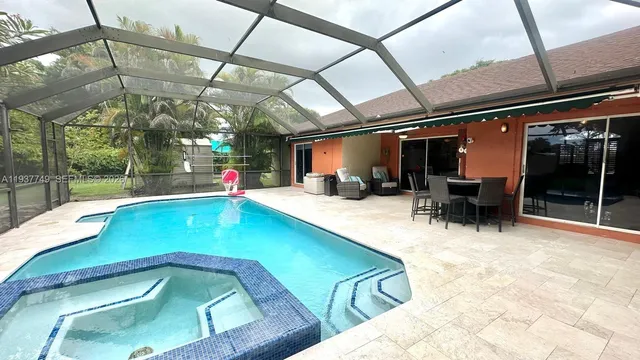 a view of swimming pool with a patio and a backyard