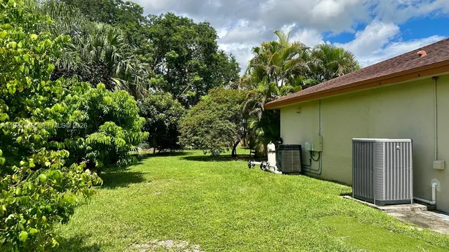 a backyard of a house with plants and wooden fence