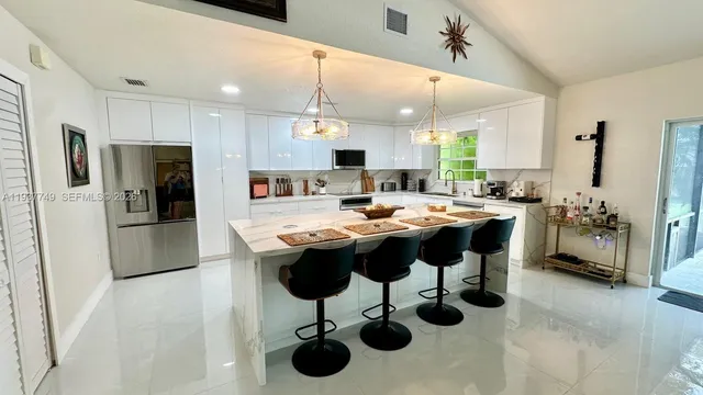 a kitchen with a sink stainless steel appliances and view living room