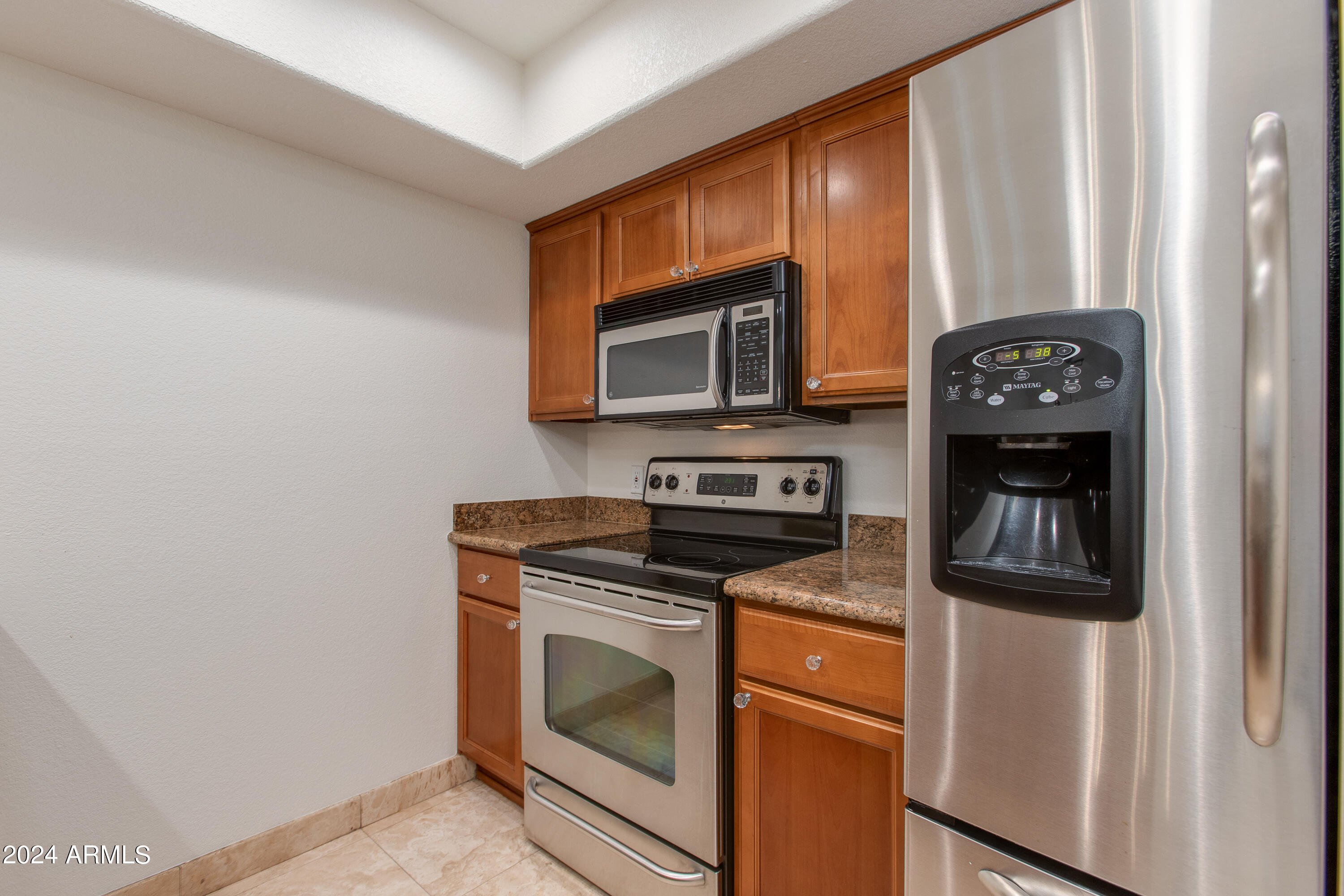 3235 East Camelback Road, Unit 118 Phoenix, AZ 85018 - Photo 4 of 12 a kitchen with granite countertop cabinets stainless steel appliances and wooden floor