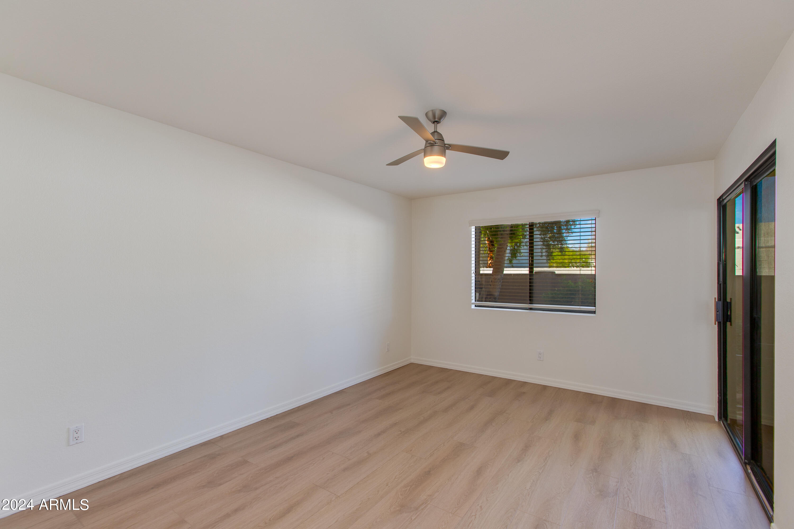 3235 East Camelback Road, Unit 118 Phoenix, AZ 85018 - Photo 8 of 12 wooden floor in an empty room with a window