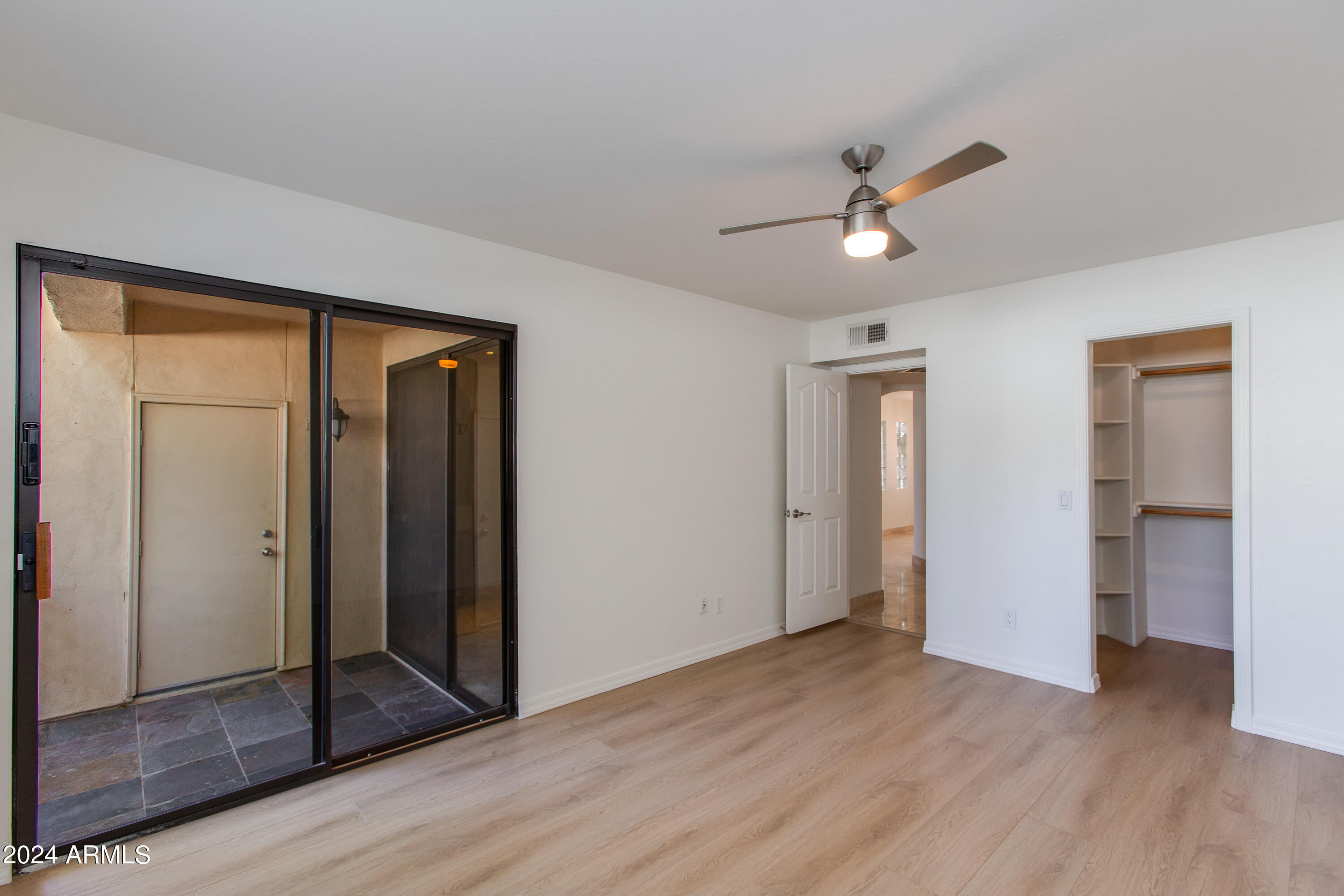 3235 East Camelback Road, Unit 118 Phoenix, AZ 85018 - Photo 9 of 12 a view of empty room with wooden floor and fan