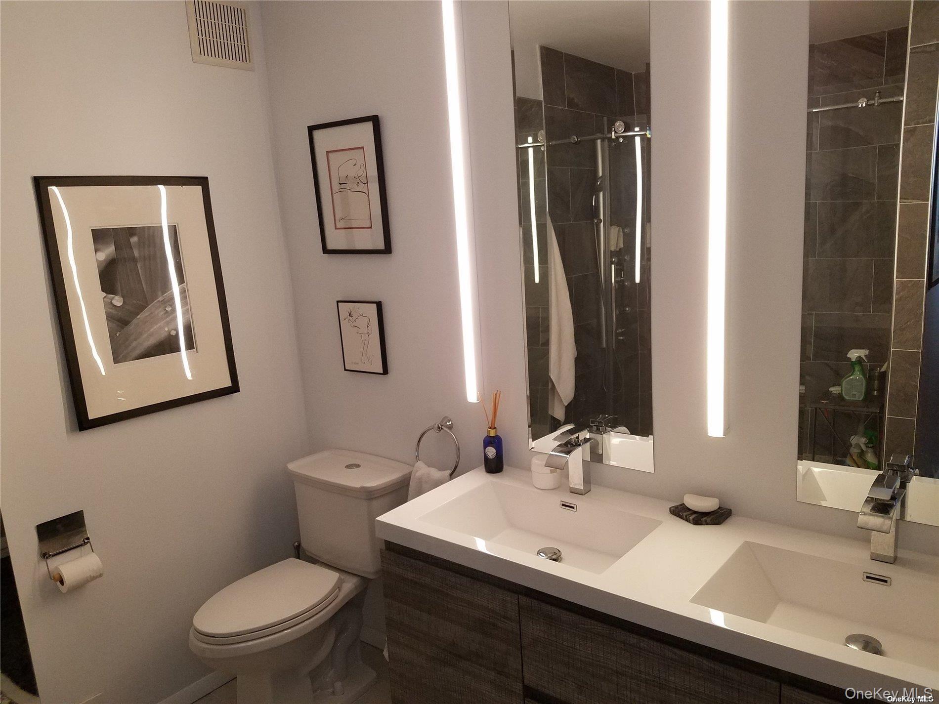 73 Spinney Road East Quogue, NY 11942 - Photo 11 of 20 a bathroom with a toilet a sink and mirror