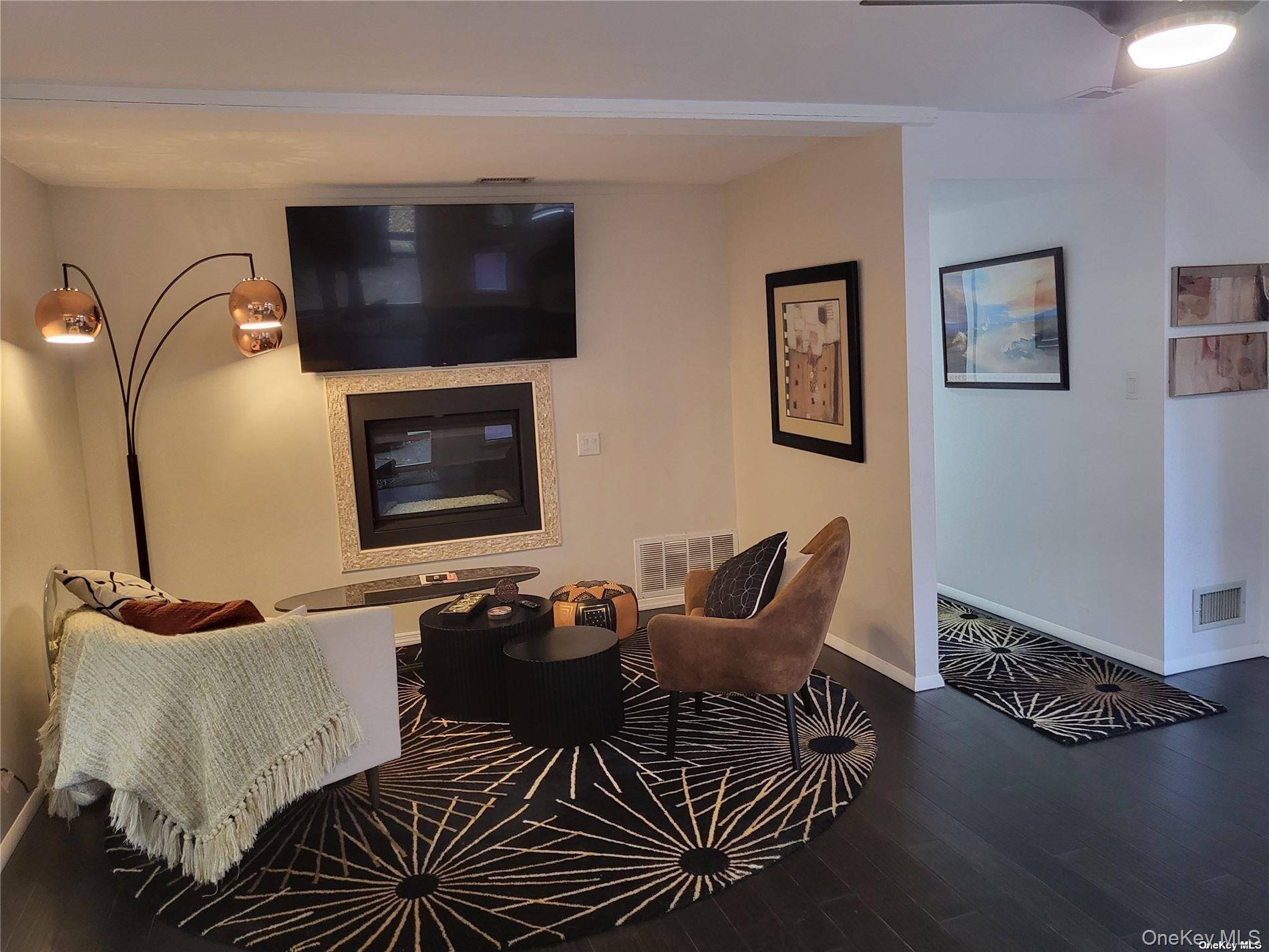 73 Spinney Road East Quogue, NY 11942 - Photo 15 of 20 a living room with furniture and a flat screen tv