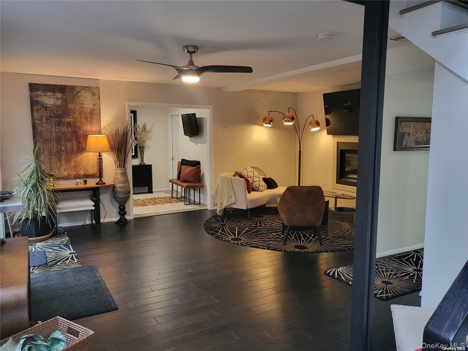 73 Spinney Road East Quogue, NY 11942 - Photo 16 of 20 a living room with furniture and a chandelier
