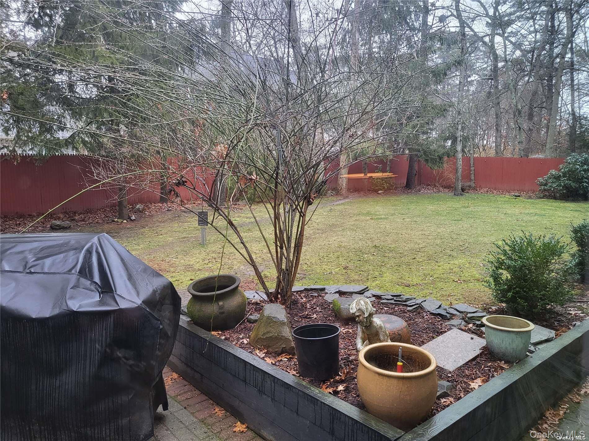 73 Spinney Road East Quogue, NY 11942 - Photo 18 of 20 a view of a backyard with table and chairs and a fire pit