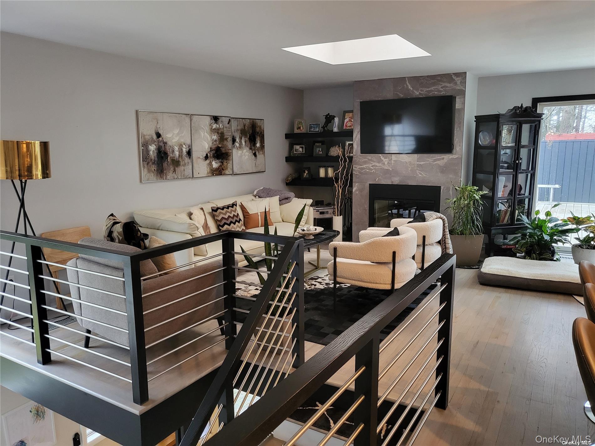 73 Spinney Road East Quogue, NY 11942 - Photo 4 of 20 a living room with furniture a flat screen tv and a fireplace