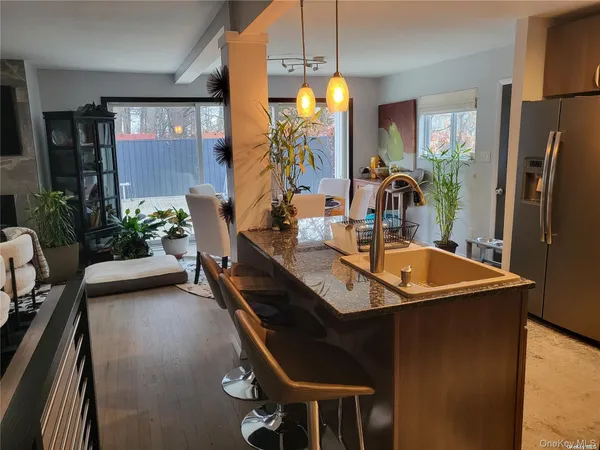 a kitchen with stainless steel appliances granite countertop a sink a stove and a refrigerator
