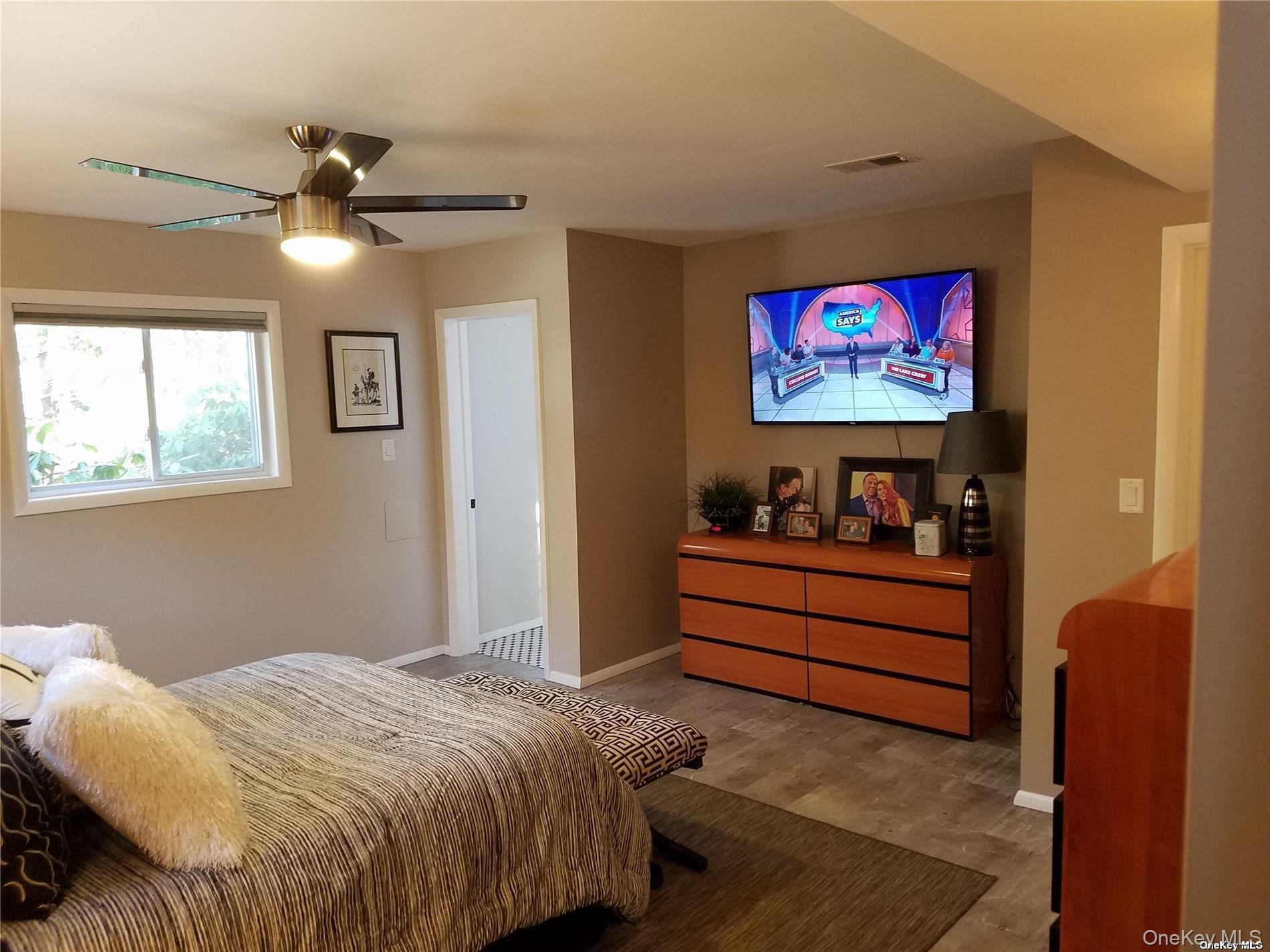 73 Spinney Road East Quogue, NY 11942 - Photo 9 of 20 a bedroom with bed and a window