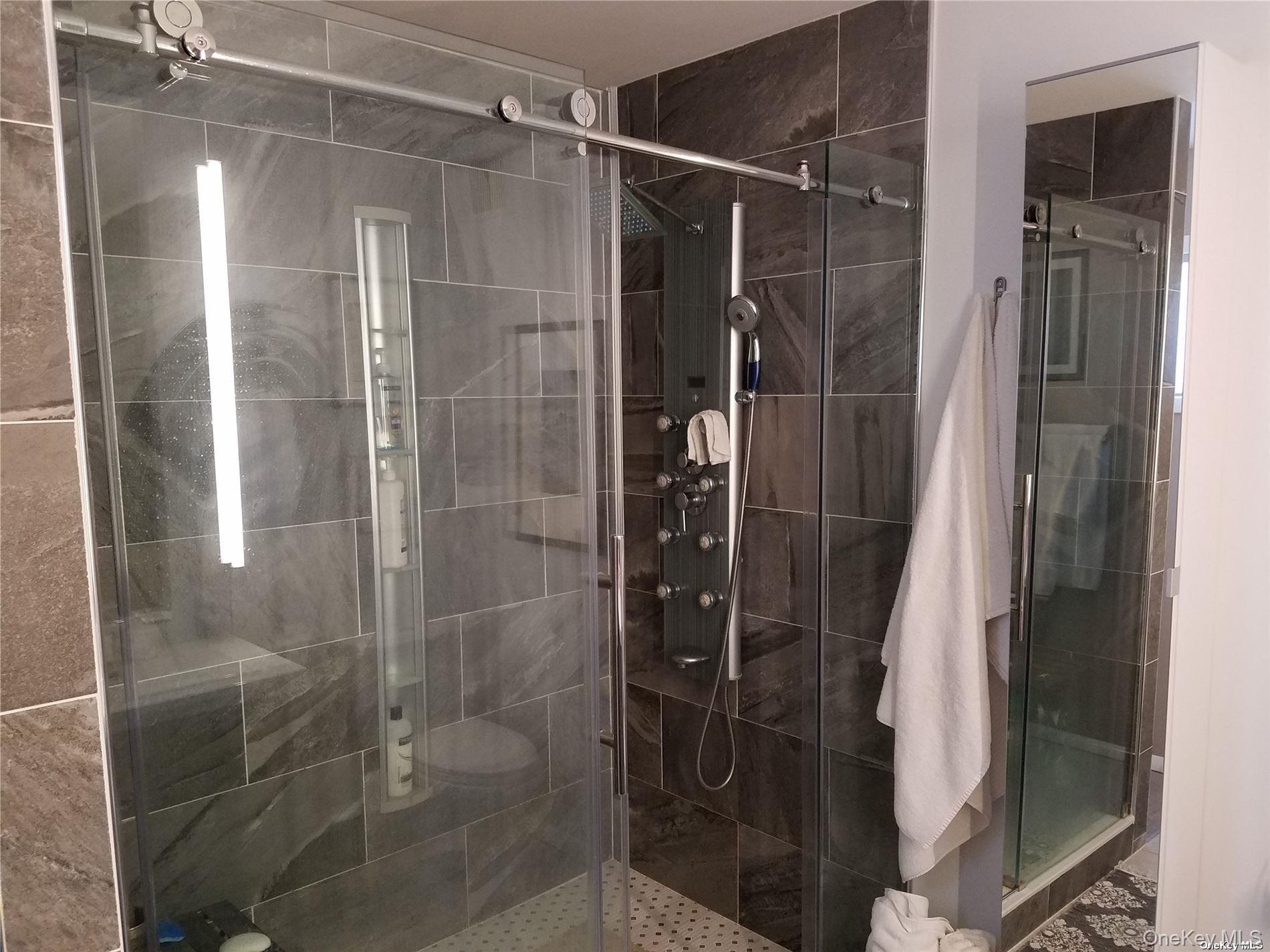 73 Spinney Road East Quogue, NY 11942 - Photo 10 of 20 a bathroom with a shower and a mirror