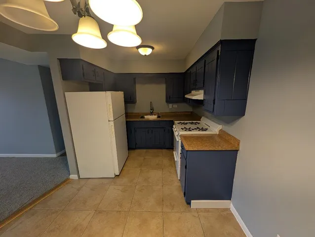 a kitchen with a refrigerator sink and cabinets