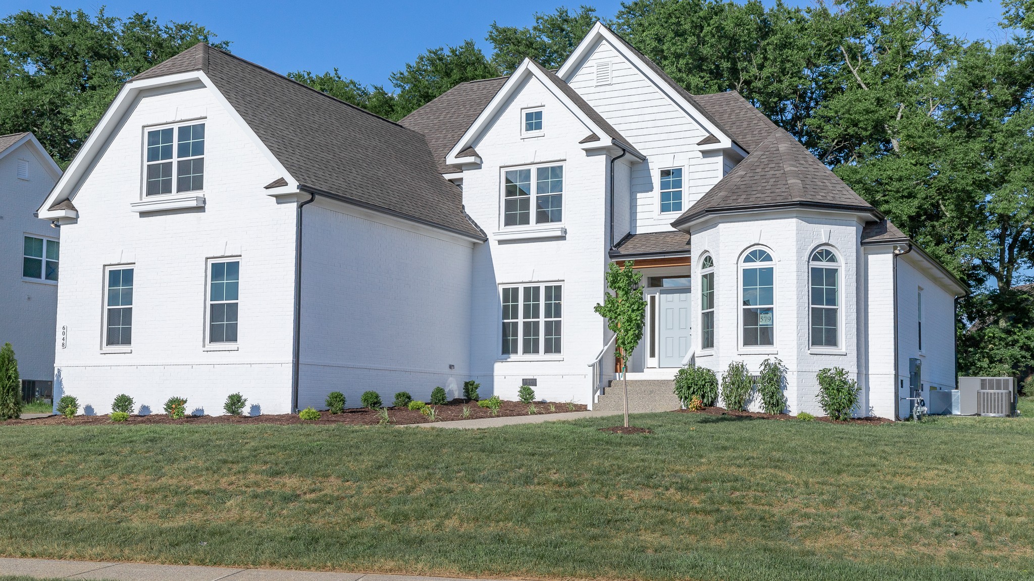 a view of a white house with yard and plants