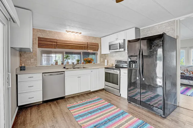 a kitchen with white cabinets and appliances