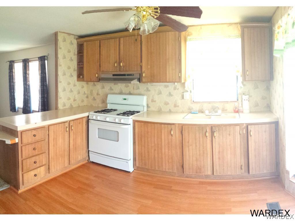 3865 Aztec Road Golden Valley, AZ 86413 - Photo 3 of 26 a kitchen with stainless steel appliances granite countertop a stove a sink and white cabinets