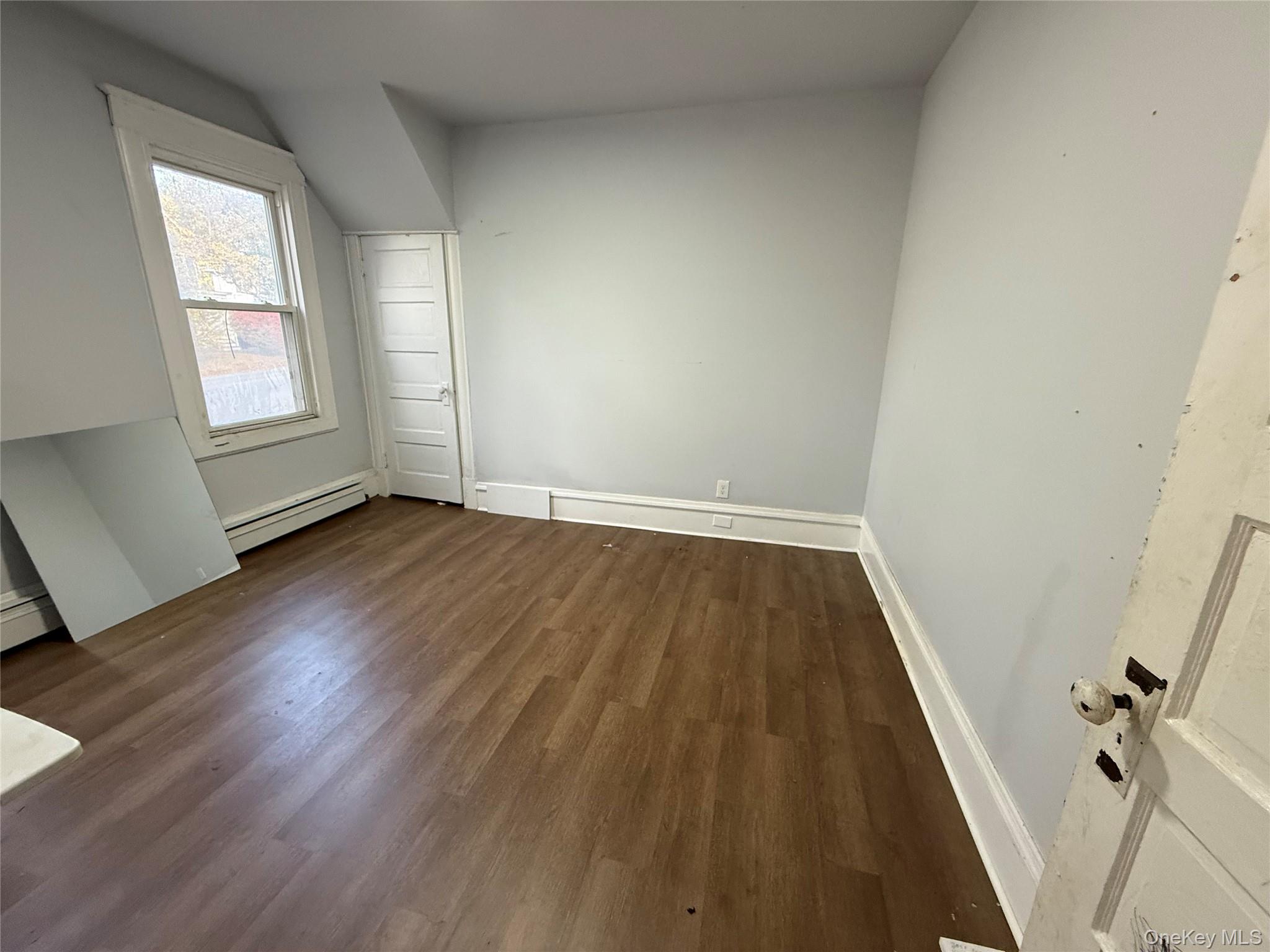 115 Innis Avenue Poughkeepsie, NY 12601 - Photo 12 of 28 2nd bedroom with dark wood finished floors and a baseboard radiator