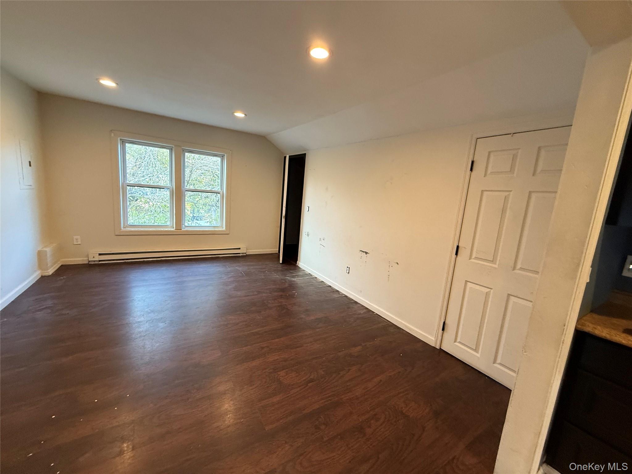115 Innis Avenue Poughkeepsie, NY 12601 - Photo 22 of 28 Empty room with dark wood-style flooring, baseboard heating, recessed lighting, lofted ceiling, and electric panel
