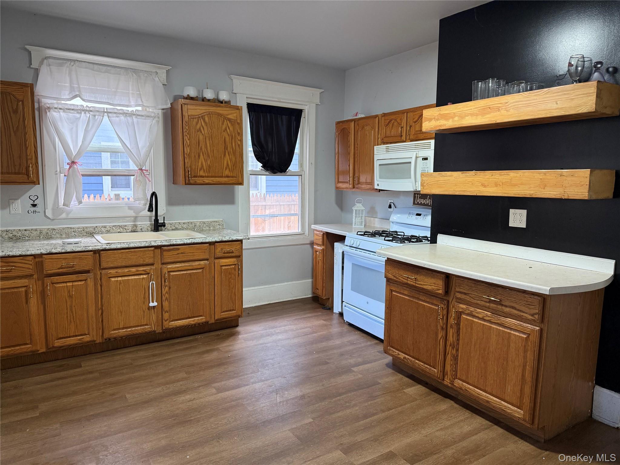 115 Innis Avenue Poughkeepsie, NY 12601 - Photo 6 of 28 1st fl Kitchen featuring white appliances, brown cabinetry, dark wood finished floors, and light countertops