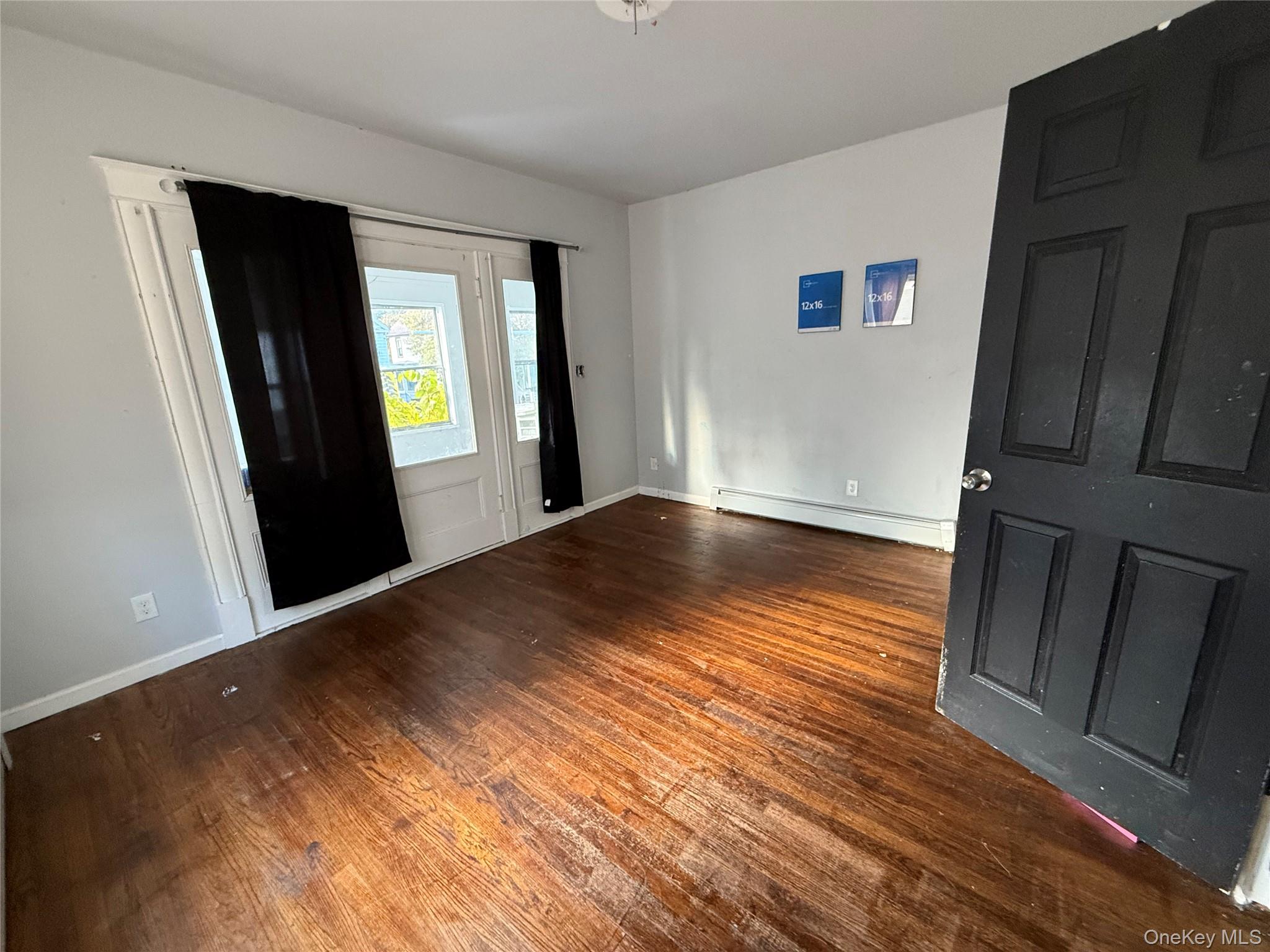 115 Innis Avenue Poughkeepsie, NY 12601 - Photo 10 of 28 Bedroom door to porch with dark wood-style flooring and baseboard heating