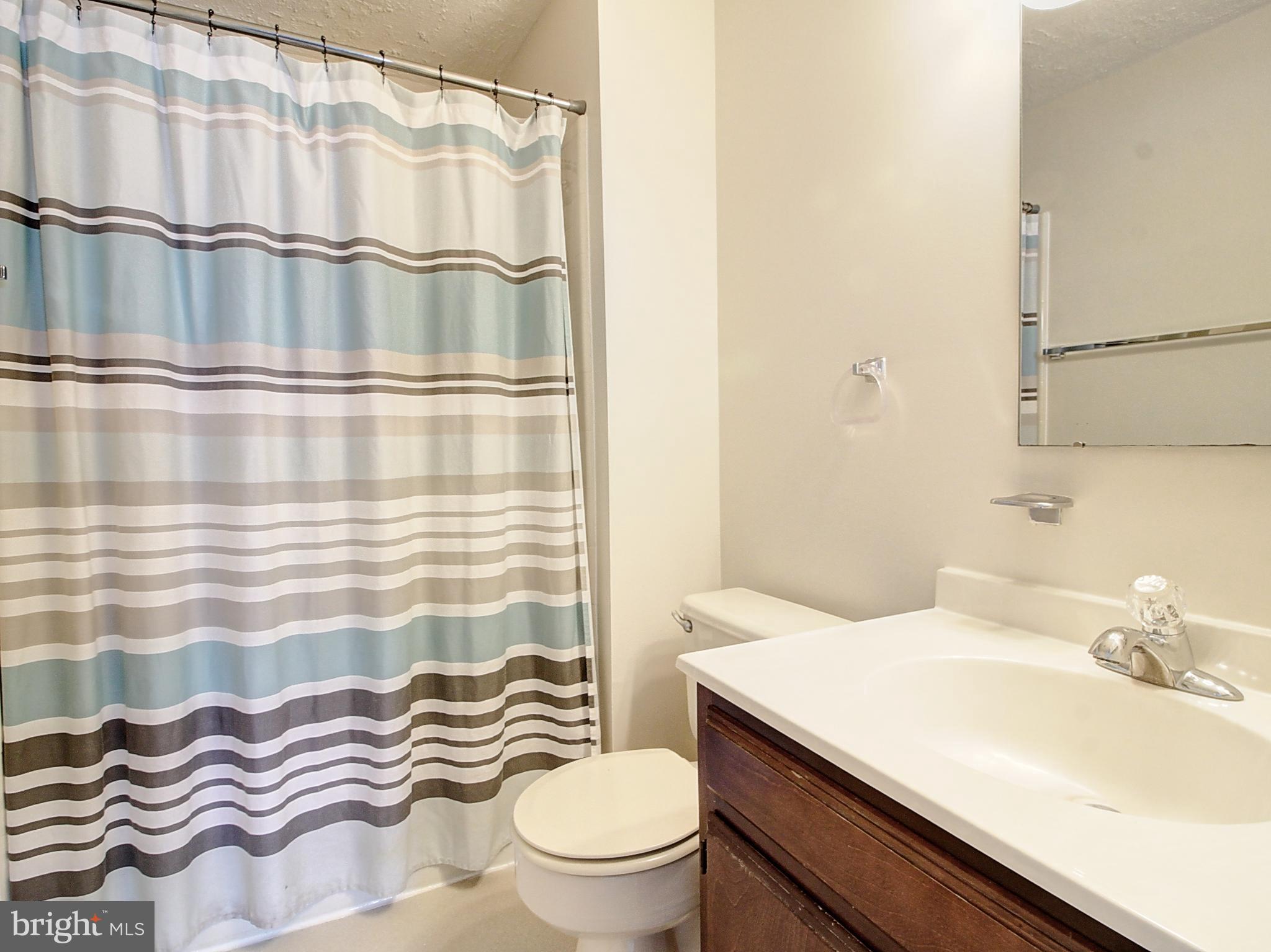7990 Quay Court Frederick, MD 21701 - Photo 13 of 16 a bathroom with a sink a toilet and shower curtain