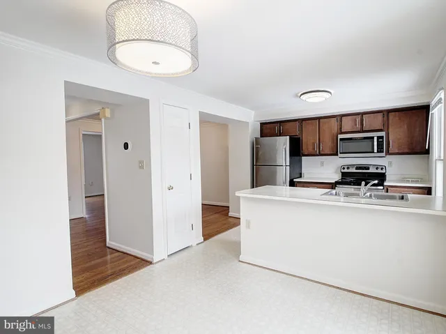 a view of kitchen with stainless steel appliances granite countertop a refrigerator a stove top oven a sink and dishwasher
