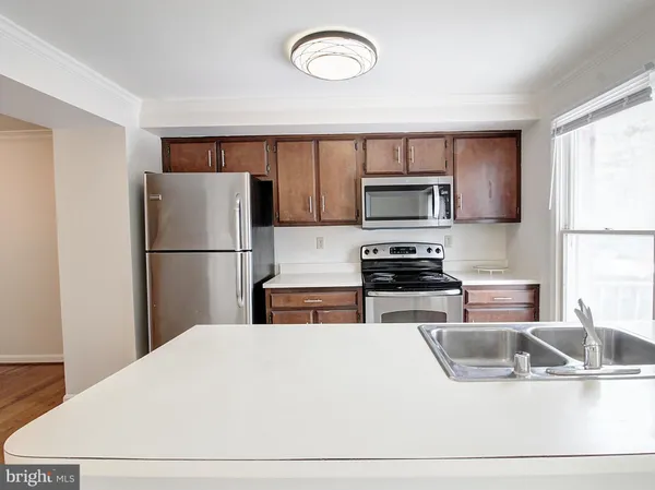 a kitchen with a refrigerator and a stove top oven