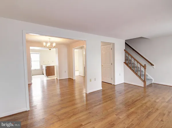 a view of an empty room with wooden floor and a large window