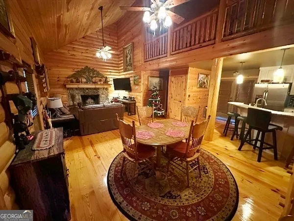 a kitchen with kitchen island granite countertop a table chairs microwave and refrigerator