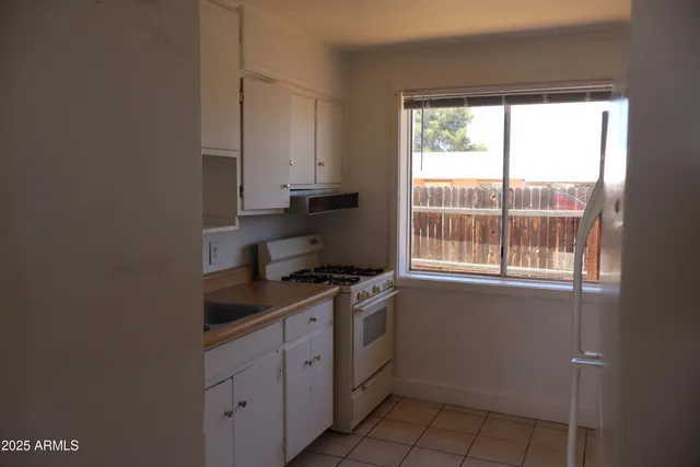 a kitchen with a stove a sink and a window