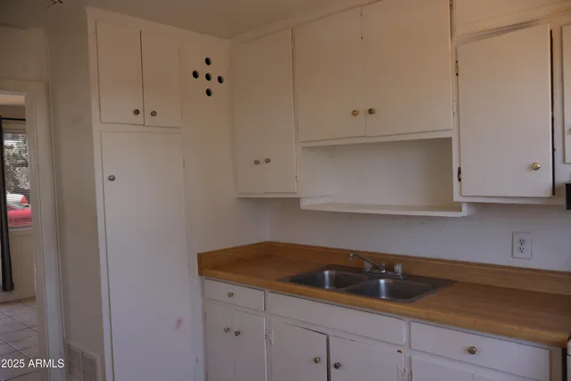 a kitchen with white cabinets and a sink
