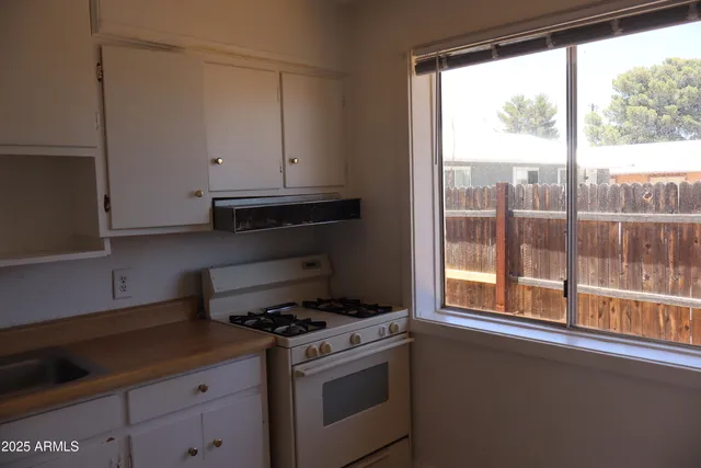a kitchen with a stove and a white cabinet